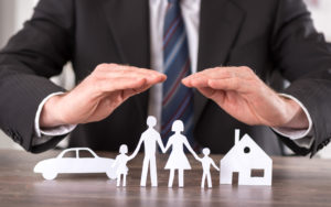 Imagem de uma pessoa com a mãos sobre bonecos simbolizando ma família, carro e casa. Imagem ilustrativa texto melhores franquias para 2022.