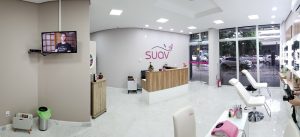 Visão do ambiente de uma franquia Suav. Observa-se na parede a logo rosa da marca. Ilustração do texto sobre franquia Suav escovaria.