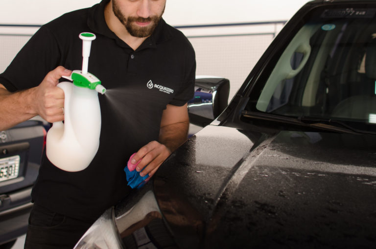 Franquia de lava rápido delivery: funcionário Acquazero fazendo limpeza de um veículo.
