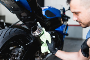 Franquia lava rápido de motos: empreendedor fazendo a limpeza do escapamento