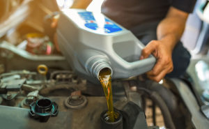 Franquias manutenção de veículos: mecanico realizando a troca de óleo no motor