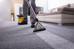 Franquia de serviços de limpeza: homem fazendo a limpeza do carpete