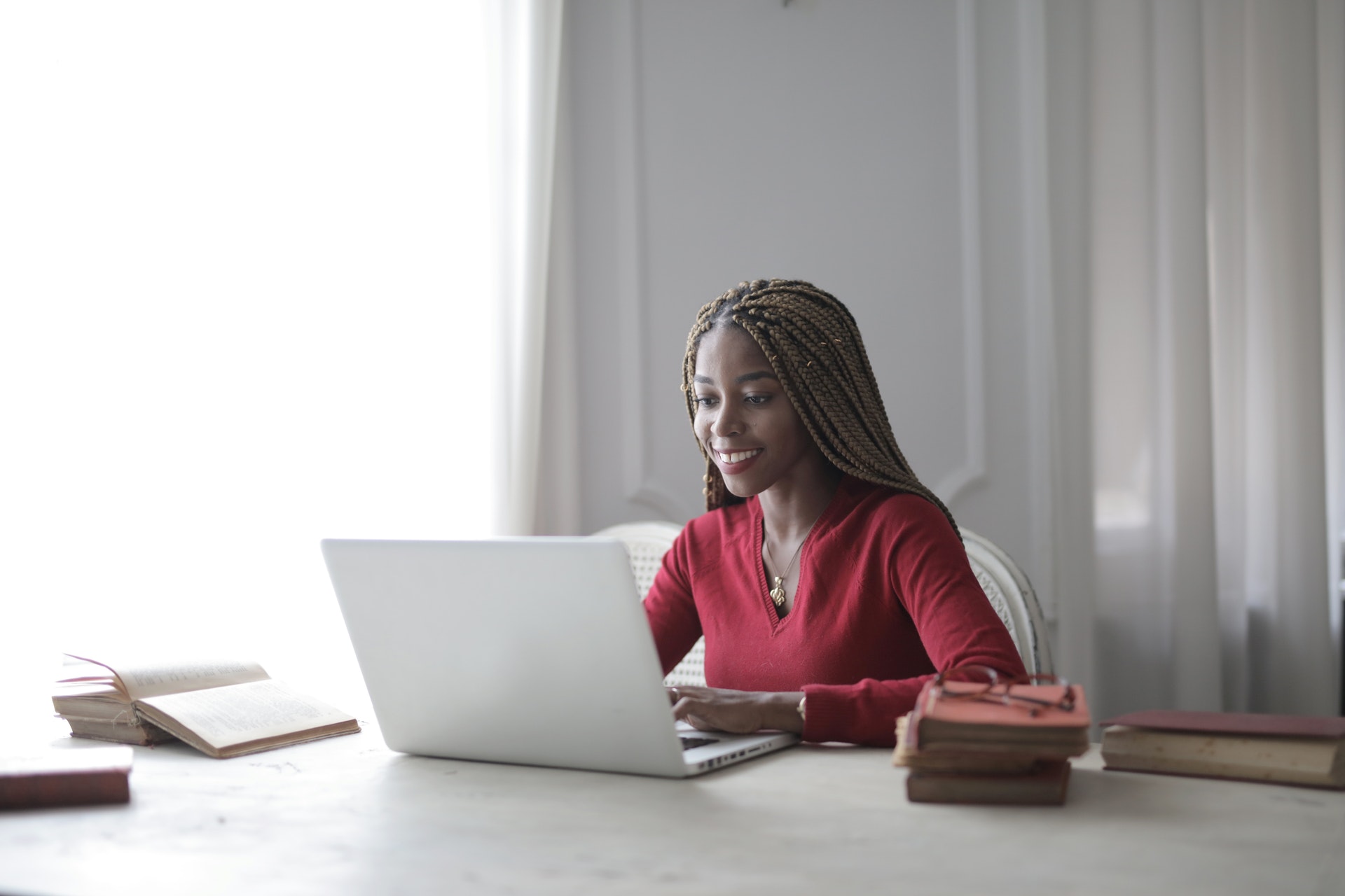 Imagem de uma mulher em casa trabalhando em frente o computador. Ilustração do texto sobre como ganhar dinheiro trabalhando com internet.