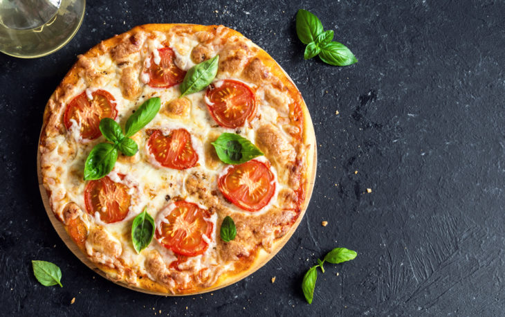 Crescimento do mercado de pizzaria: pizza de marguerita sobre uma mesa pedra