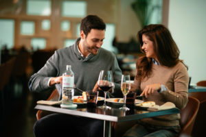 Franquia de restaurante: casal em uma mesa almoçando com vinho e água na mesa