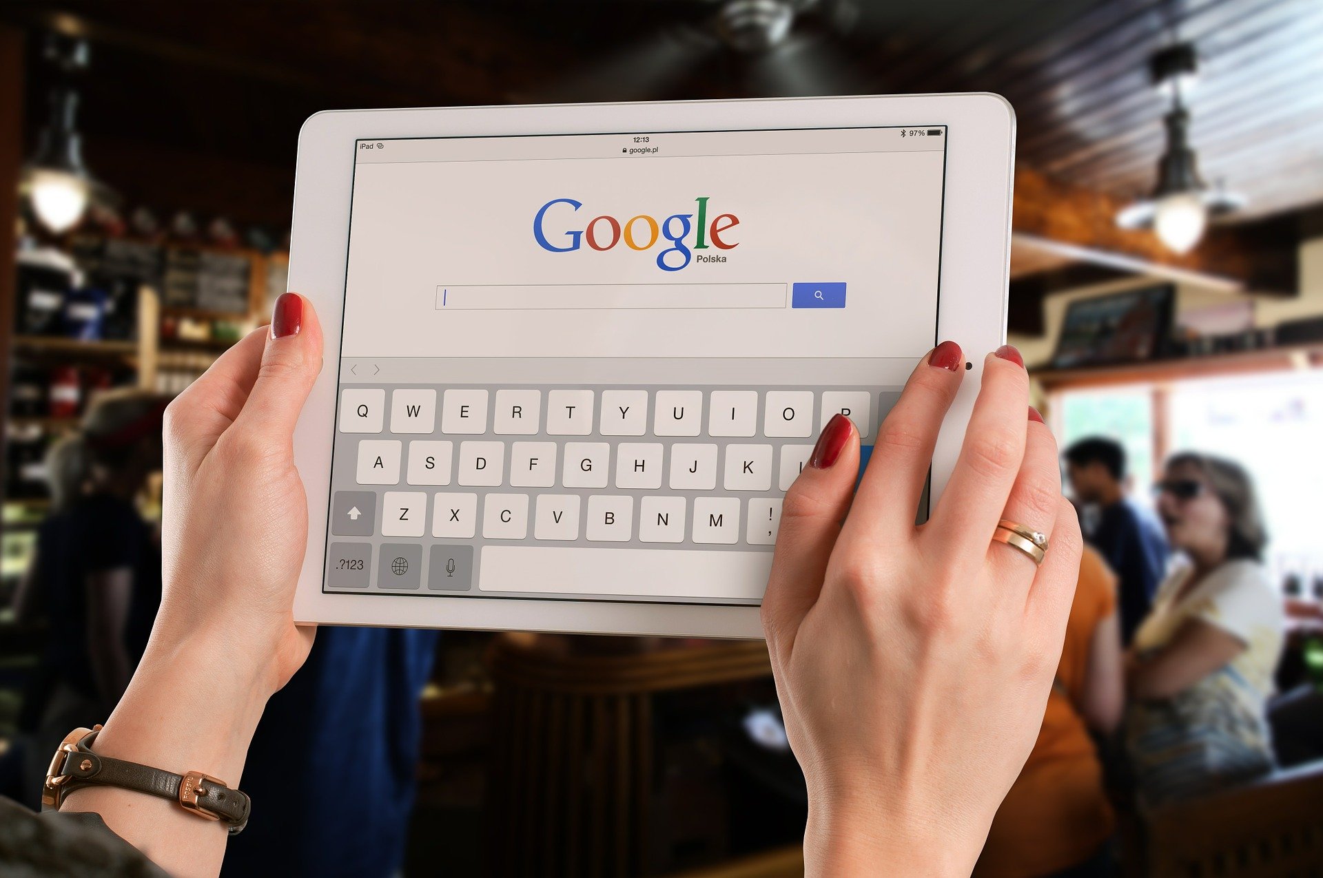 Vemos que uma pessoa segura um tablet com o Google em tela, em um restaurante (imagem ilustrativa). Texto: franquias de alimentação.