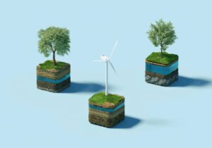 Foto de um fundo azul com três blocos, sendo dois deles com árvores e um deles um sistema de energia eólica. Imagem ilustrativa para texto empreendedorismo verde.