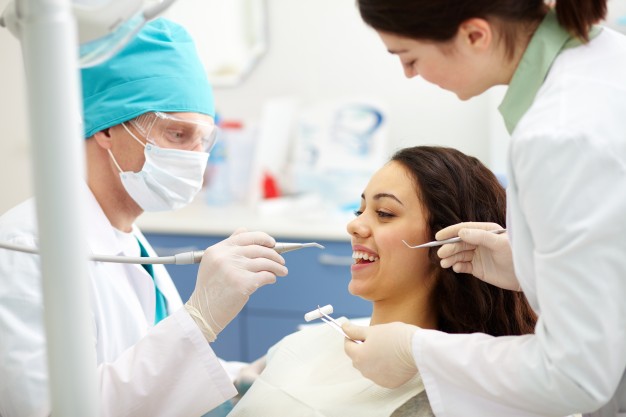 mulher passando por procedimento com odontologista. 