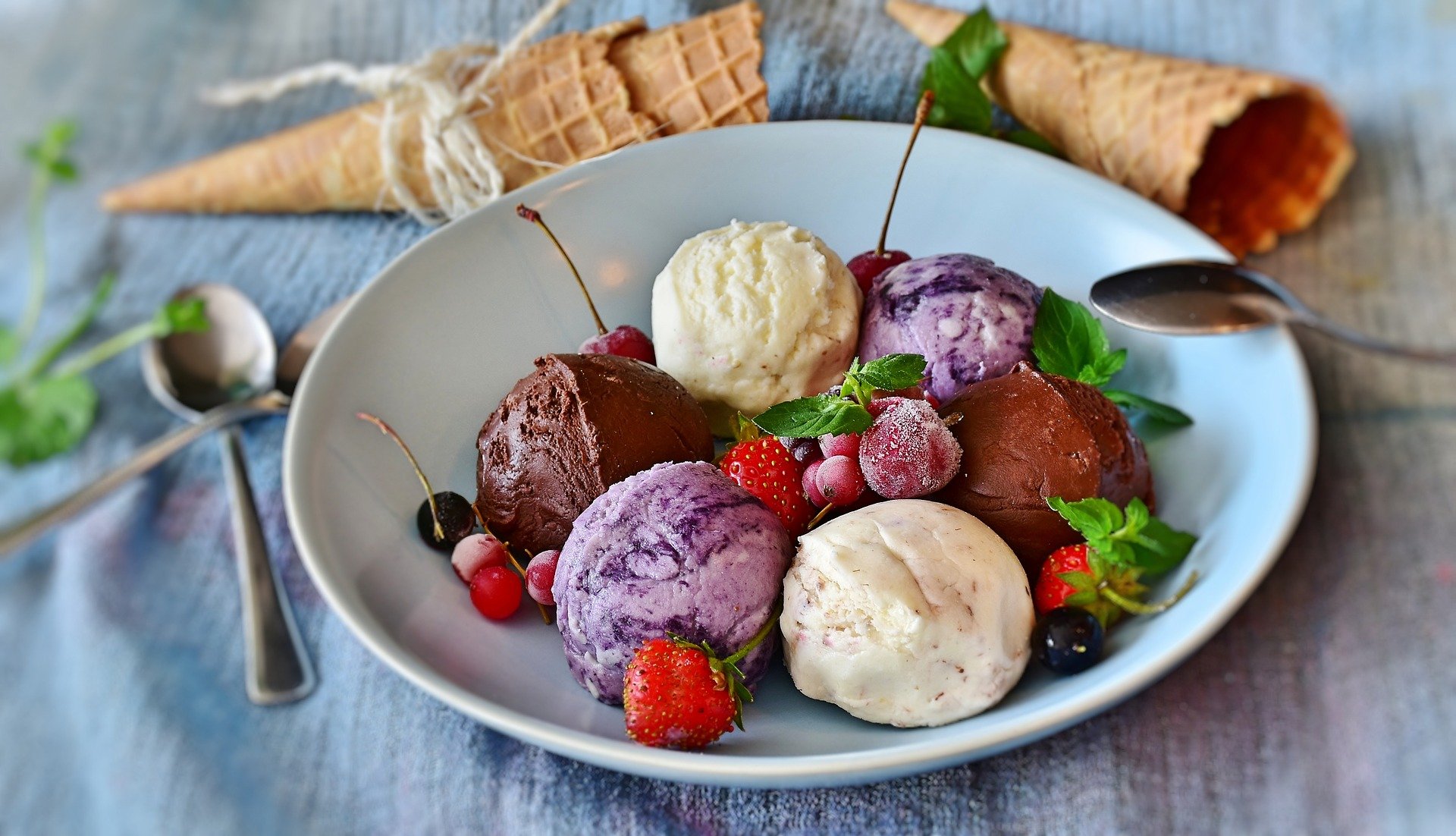 Imagem de um prato com sorvetes coloridos muito bem decorados com frutos silvestres (imagem ilustrativa). Texto: como montar uma sorveteria.