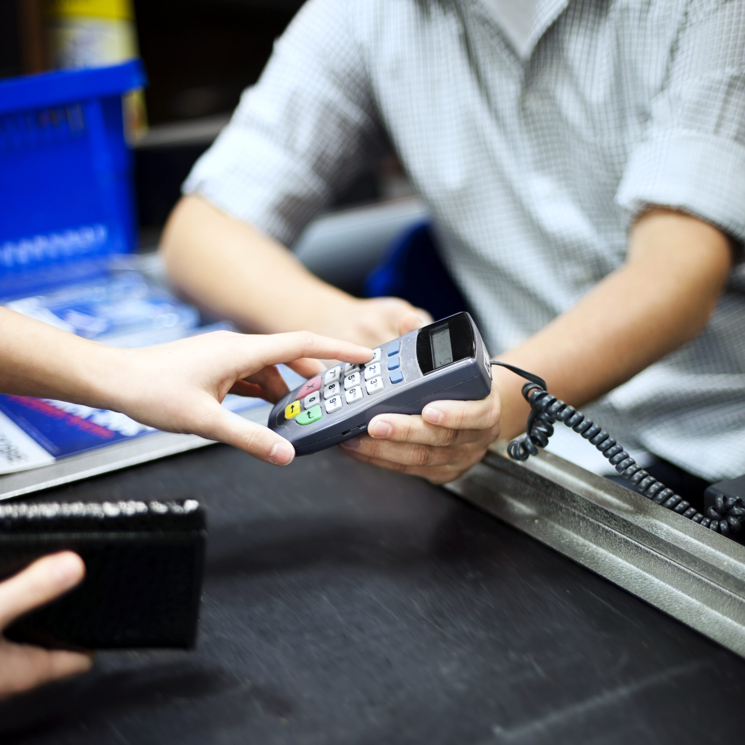 Imagem de uma pessoa digitando a senha em uma máquina de cartão de crédito. Imagem ilustrativa de texto franquias baratas serviços 2021.