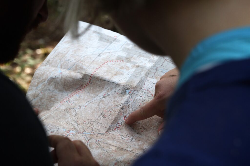 Foto de duas pessoas consultando e apontando algo em um mapa.