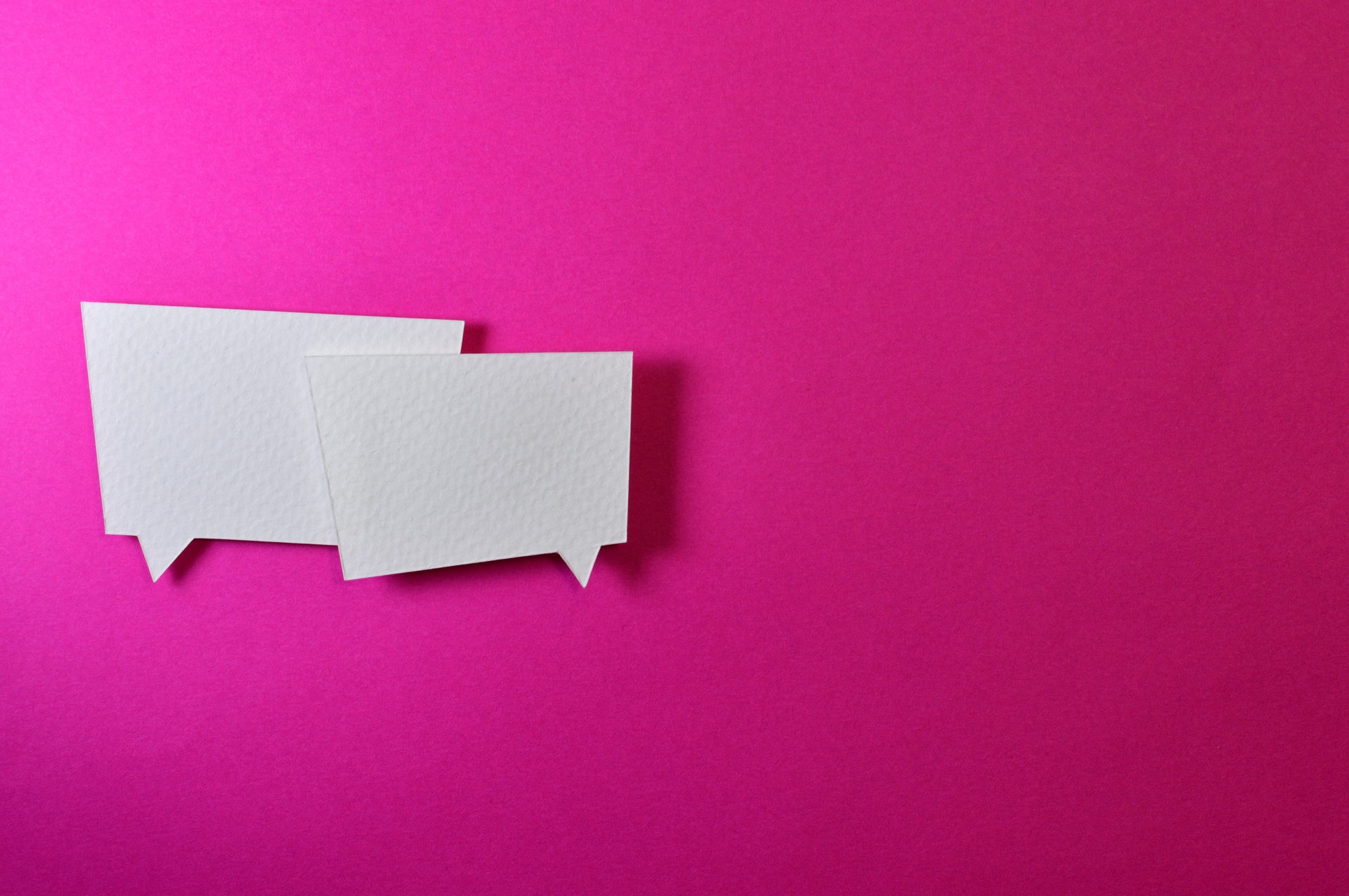Imagem de um fundo rosa com duas caixas de diálogo. Imagem ilustrativa para o texto comunicação estratégica.