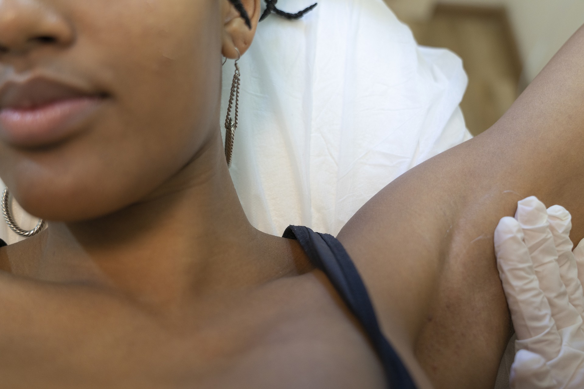 Imagem de uma mulher negra fazendo a depilação da axila. Ilustração do texto franquia de depilação.