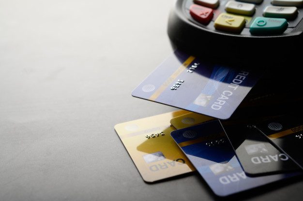 Imagem de cartões de crédito e de uma máquia de cartão. Imagem ilustrativa texto franquias que podem ser financiadas.