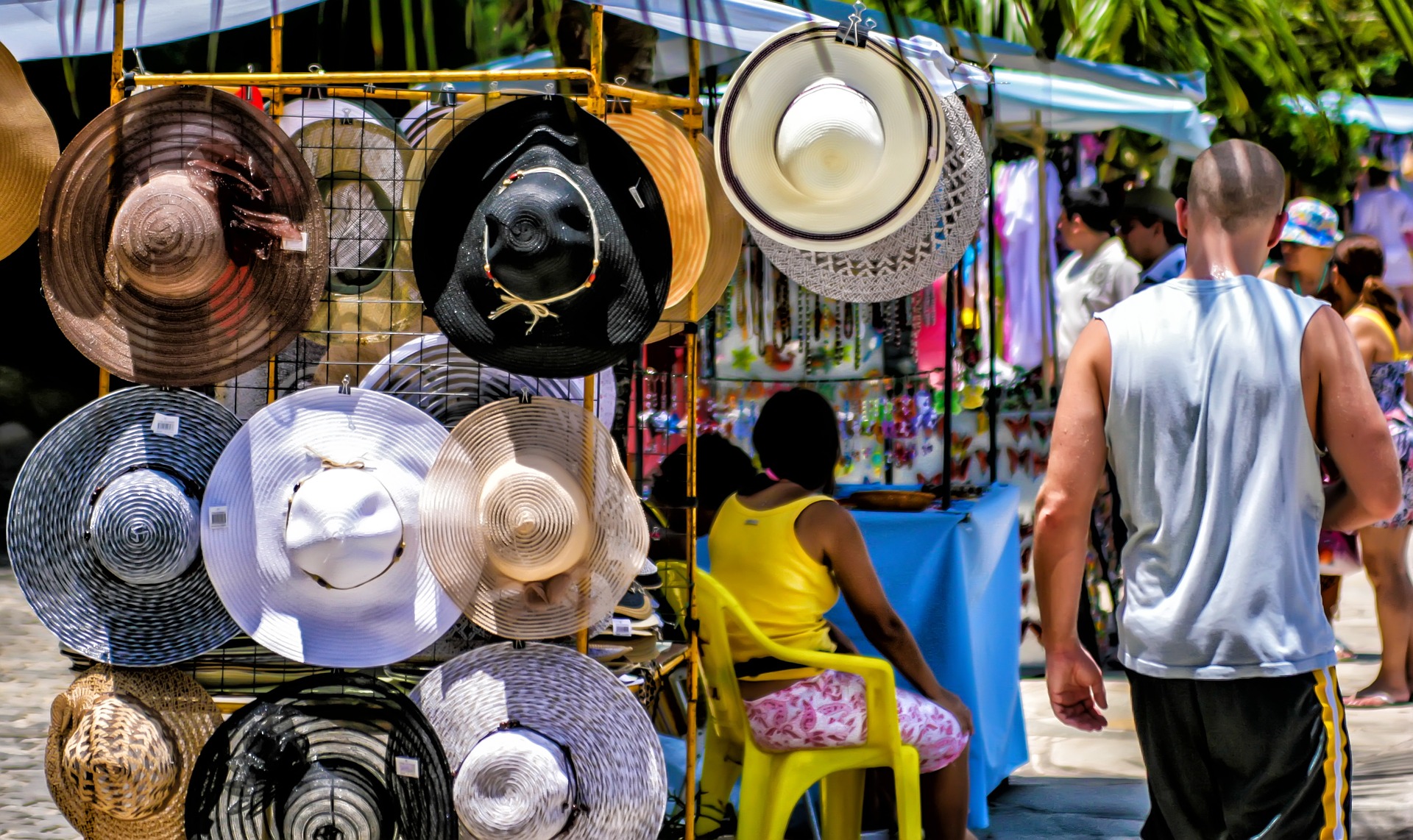 Vemos uma barraca de venda de chapéus em uma feria livre (imagem ilustrativa).