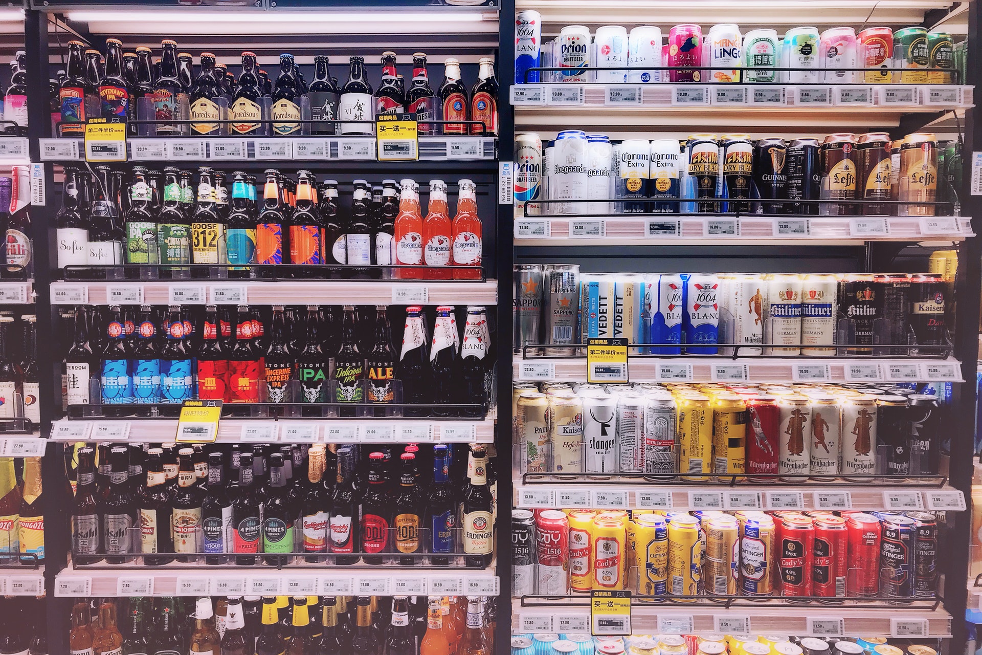 Vemos uma prateleira cheia de bebidas em uma loja (imagem ilustrativa). Texto: como abrir uma franquia de bebidas.