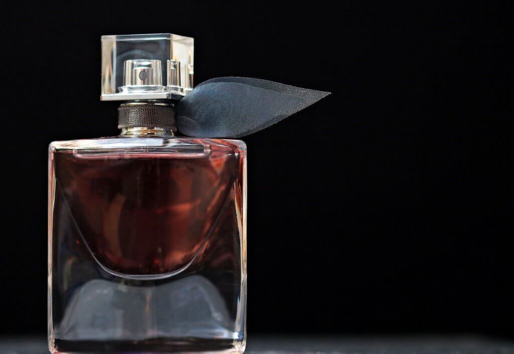 Foto de vidro de um perfume com laço de enfeite. Imagem ilustrativa para texto franquias brasileiras.