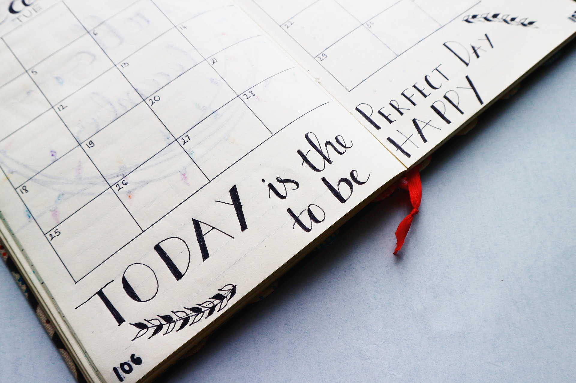 Vemos um caderno de organização diária com um calendário (imagem ilustrativa).