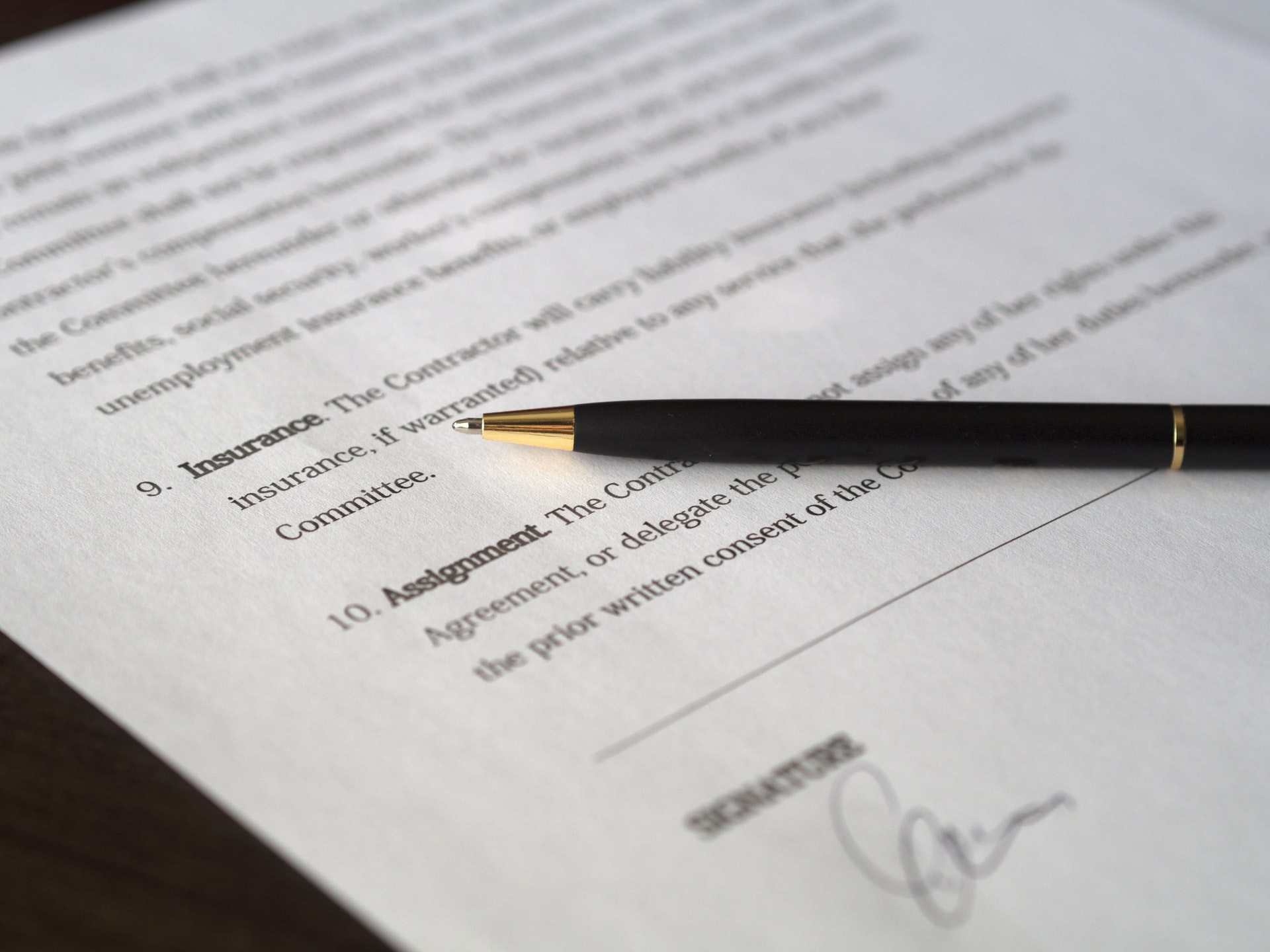 Imagem de um contrato e uma caneta em cima dele. Imagem ilustrativa texto cláusula de não concorrência em franquias.
