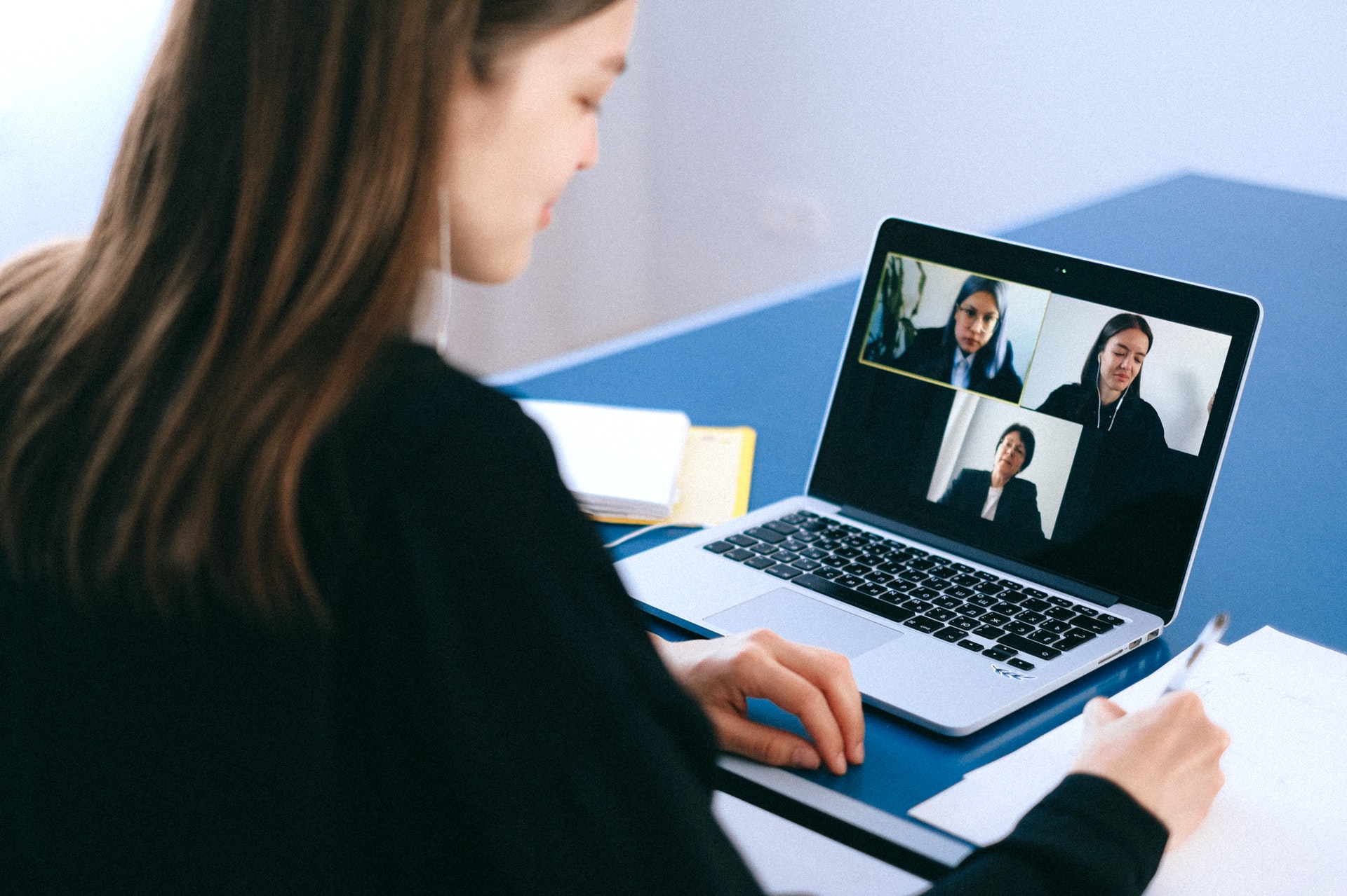 Imagem de uma mulher em frente um computador conversando com outras pessoas pela tela do computador. Imagem ilustrativa texto melhores negócios home office.