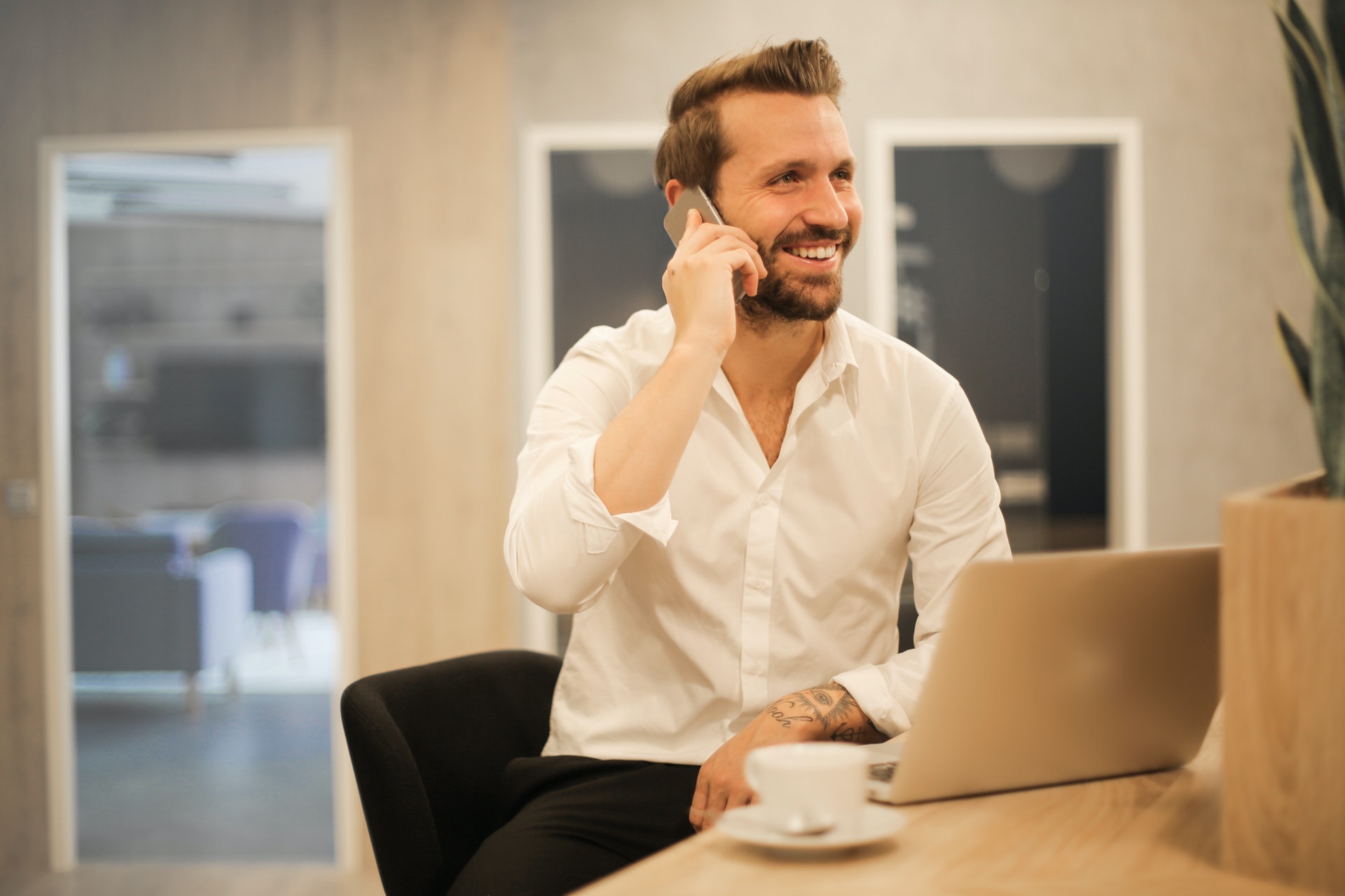 Imagem de um empresario falando ao telefone e sorrindo. Imagem ilustrativa texto começar o próprio negócio.