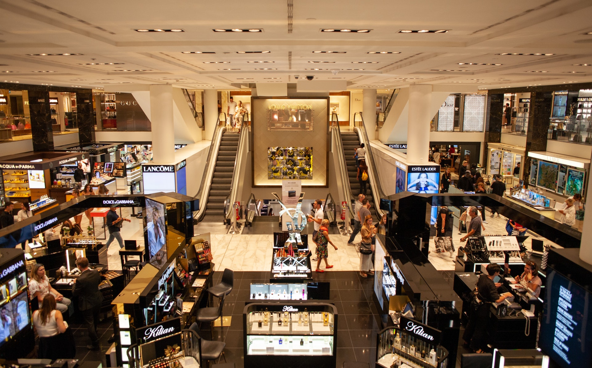 Imagem de um shopping com lojas e escadas rolantes. Imagem ilustrativa texto franquia de rua ou franquia em shopping.
