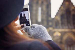 moça tirando foto com o celular de ponto turístico ilustrativo franquia de turismo é boa investir