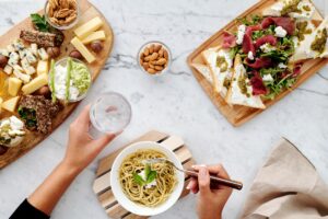 Imagem de uma mesa com pratos de macarrão e outros alimentos. Imagem ilustrativa texto franquias baratas alimentação 2022.