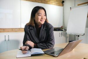 Imagem de uma empresária sentada em frente um computador. Imagem ilustrativa texto franquias boas e baratas 2022.