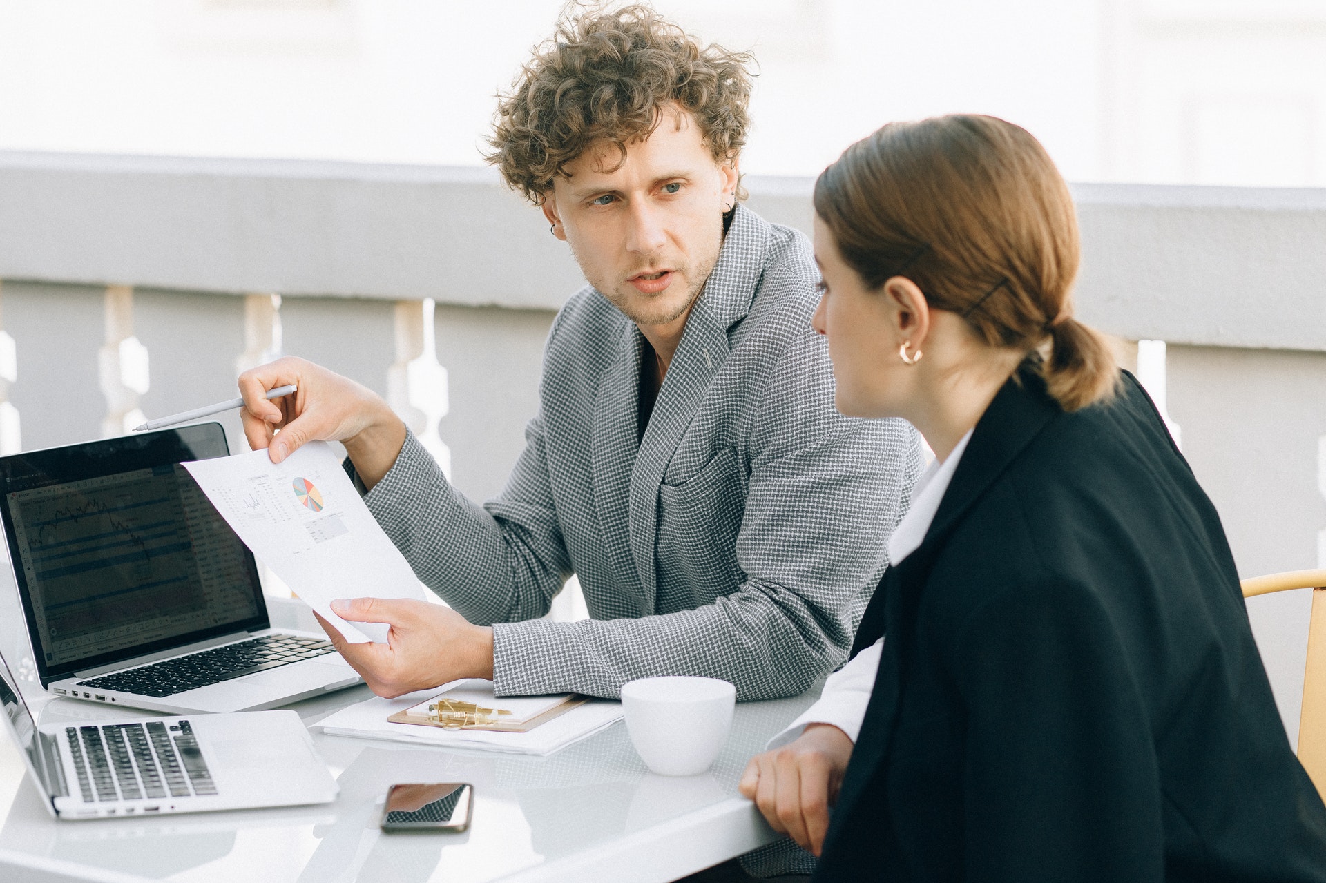 Homem dando uma consultoria para uma mulher em uma sala de escritório. Imagem ilustrativa do texto gestão empresarial franquia.