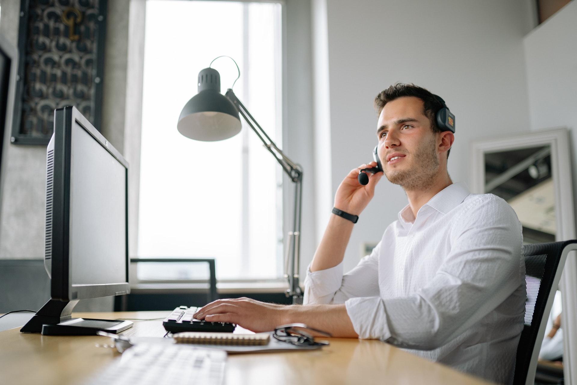 Imagem de um homem ao telefone sentado em uma mesa de escritório. Imagem ilustrativa texto suporte da franqueadora.
