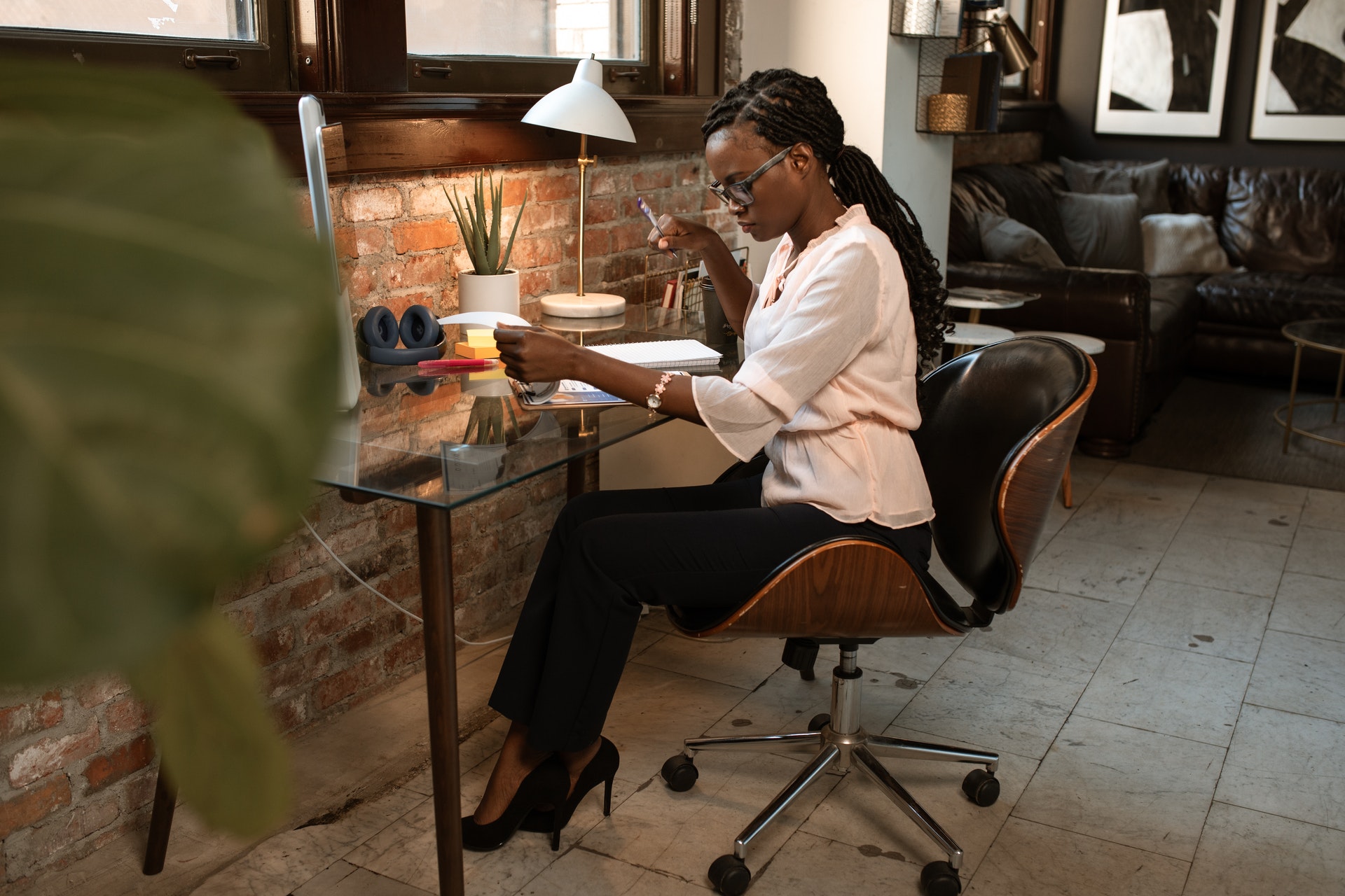 Imagem de uma mulher trabalhando em uma mesa localizada em casa. Imagem ilustrativa texto empreendedorismo de impacto.