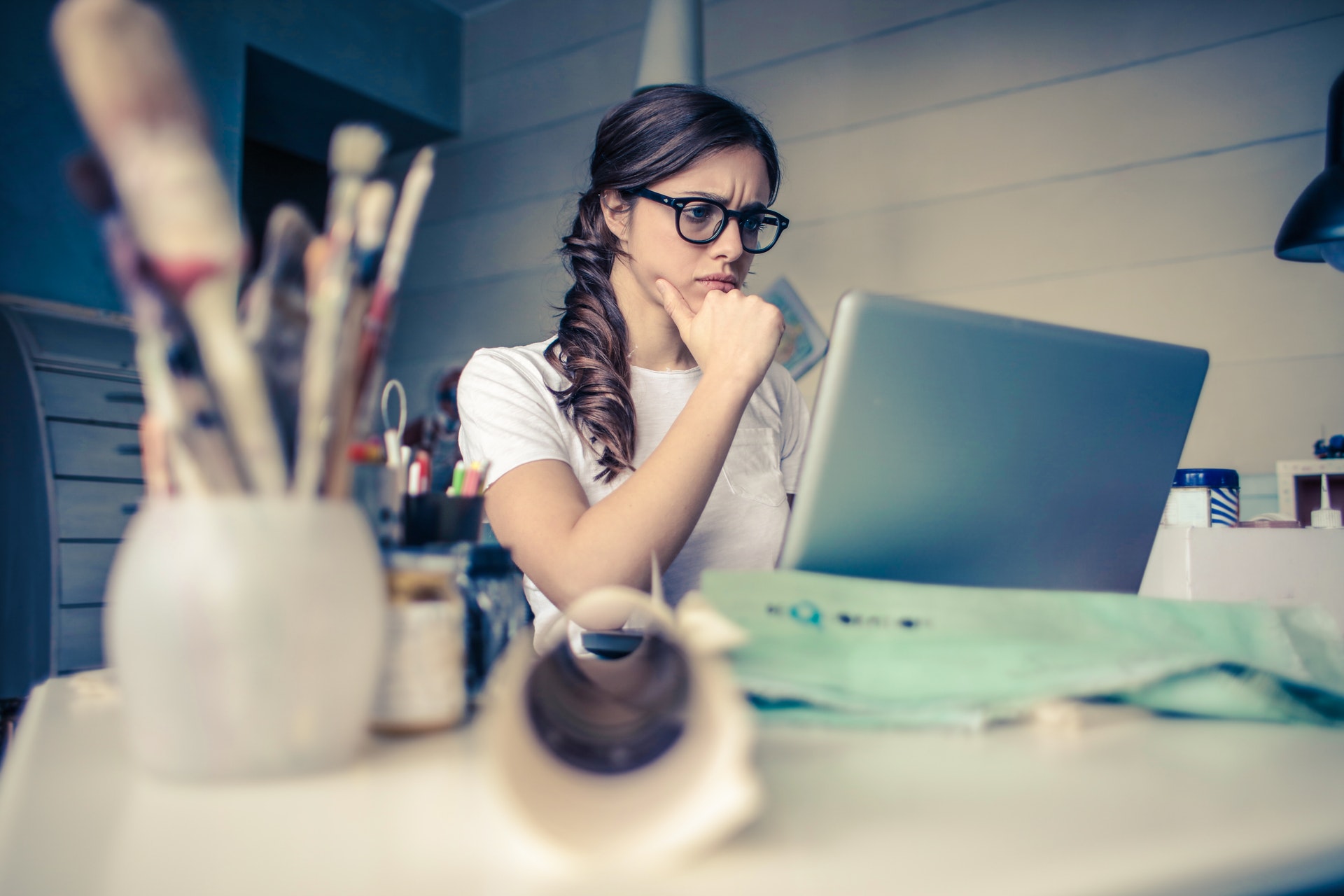 Imagem de uma mulher pensativa em frente um computador. Imagem ilustrativa texto ideia de negócios.