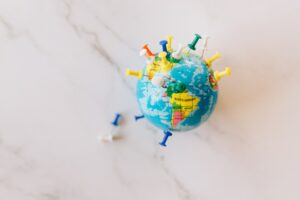 Imagem de um pequeno globo terrestre com marcadores pregados dele. Imagem ilustrativa texto internacionalização de empresas.