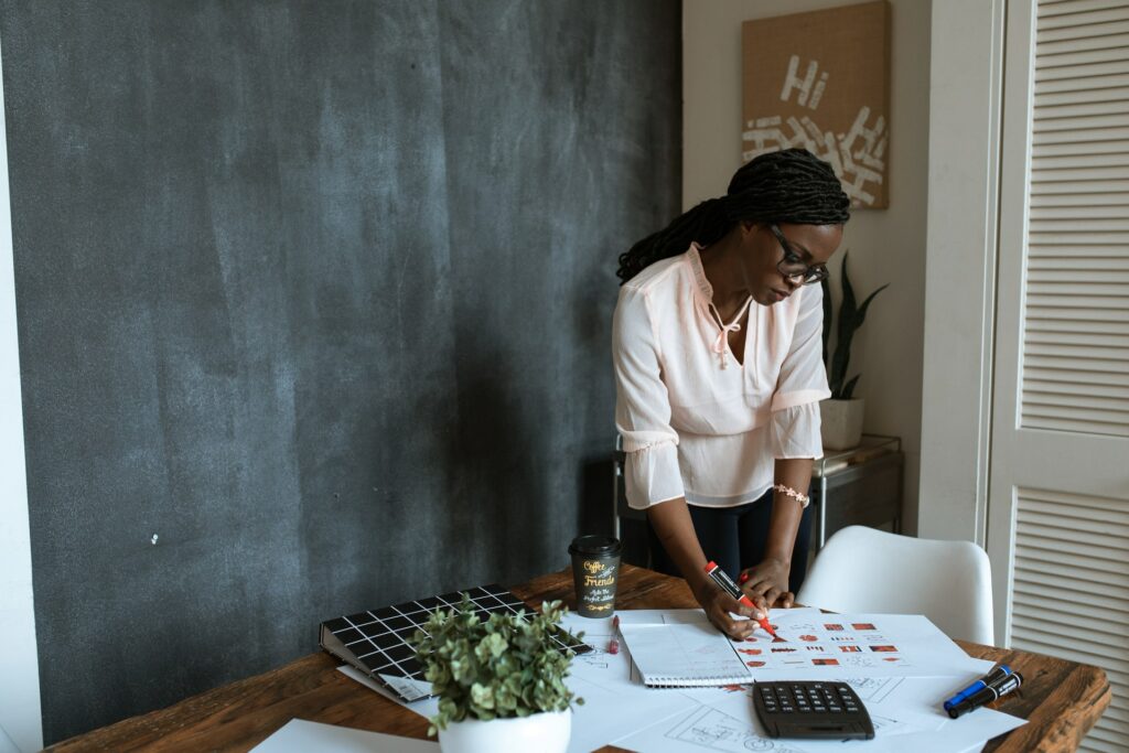 Imagem de uma mulher trabalhando em uma mesa. Imagem ilustrativa texto melhor ideia de negócio.