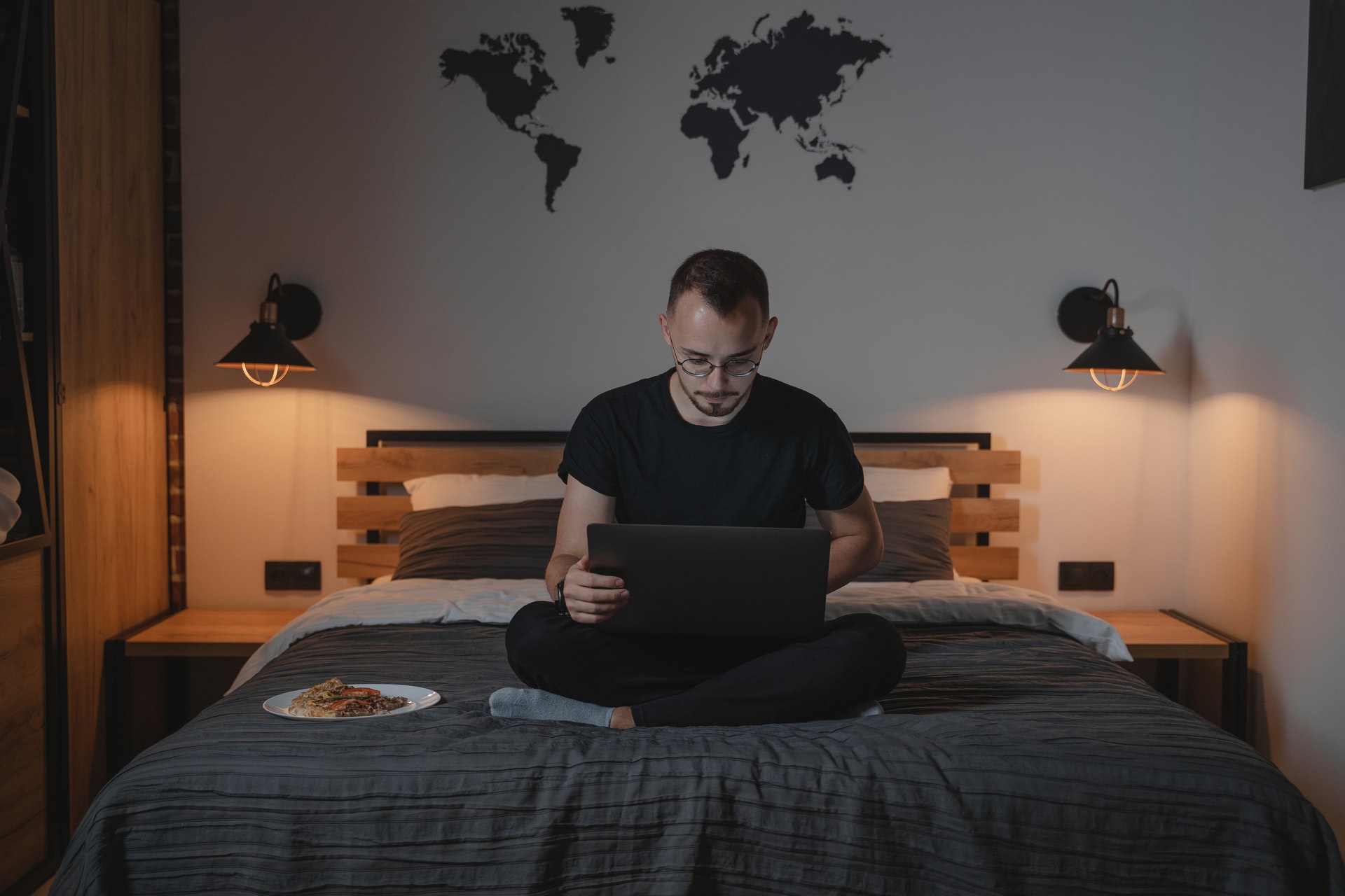Imagem de um homem sentando na cama mexendo no computador. Imagem ilustrativa texto negócios incríveis.