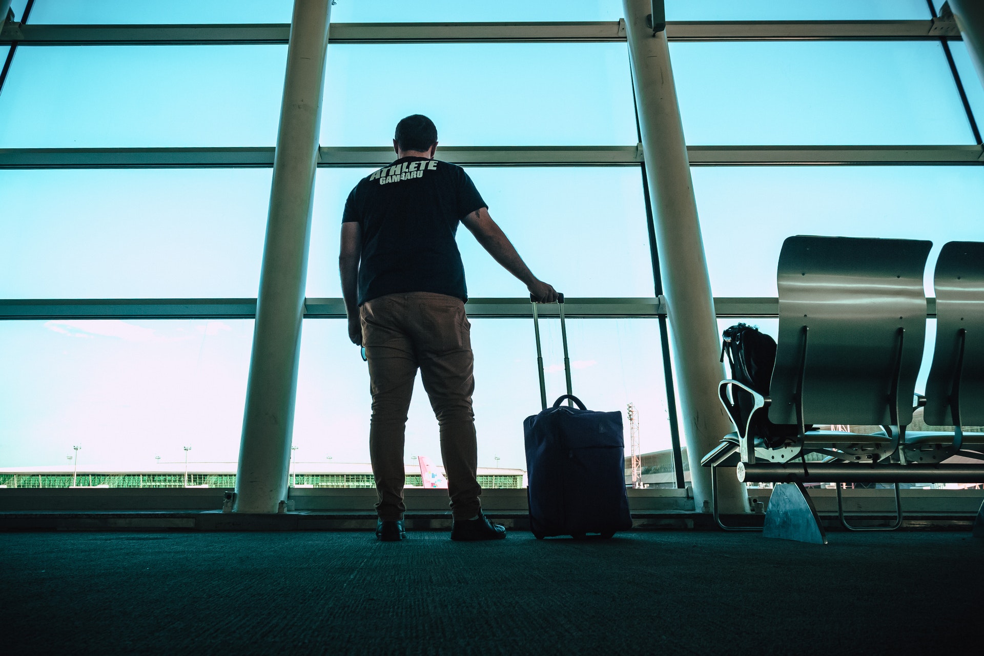 Imagem de um homem segurando uma mala de viagem em um aeroporto. Imagem ilustrativa texto negócios incríveis.