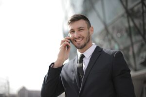 Imagem de um empresário sorrindo usando um telefone. Imagem ilustrativa texto negócios incríveis.