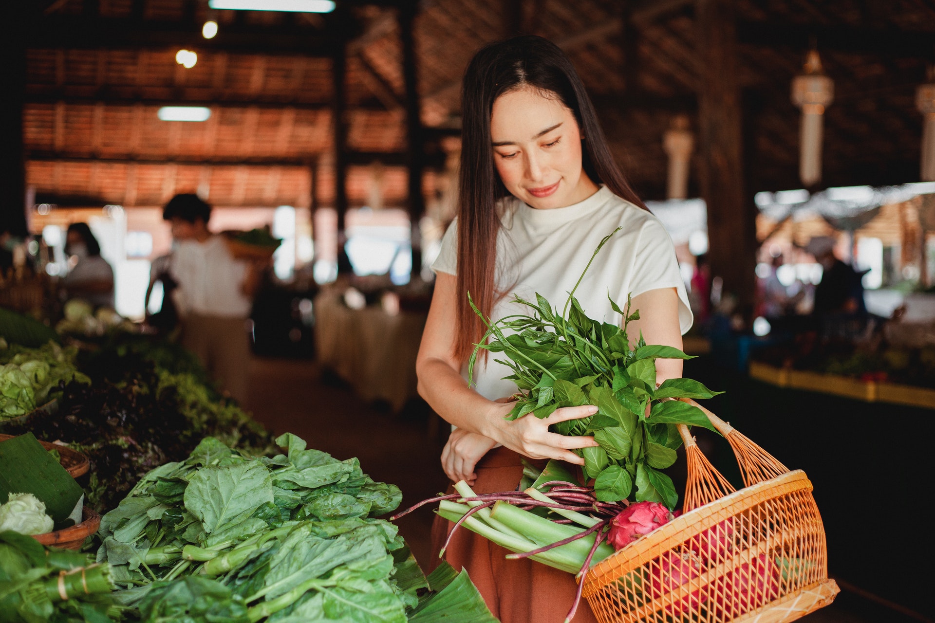 Imagem de uma mulher comprando vegetais em um estabelecimento. Imagem ilustrativa texto alavancar o meu negócio.