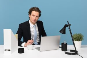 Imagem de um empresário em sua mesa com um computador e outros objetos de escritório. Imagem ilustrativa texto franqueados bem-sucedido.