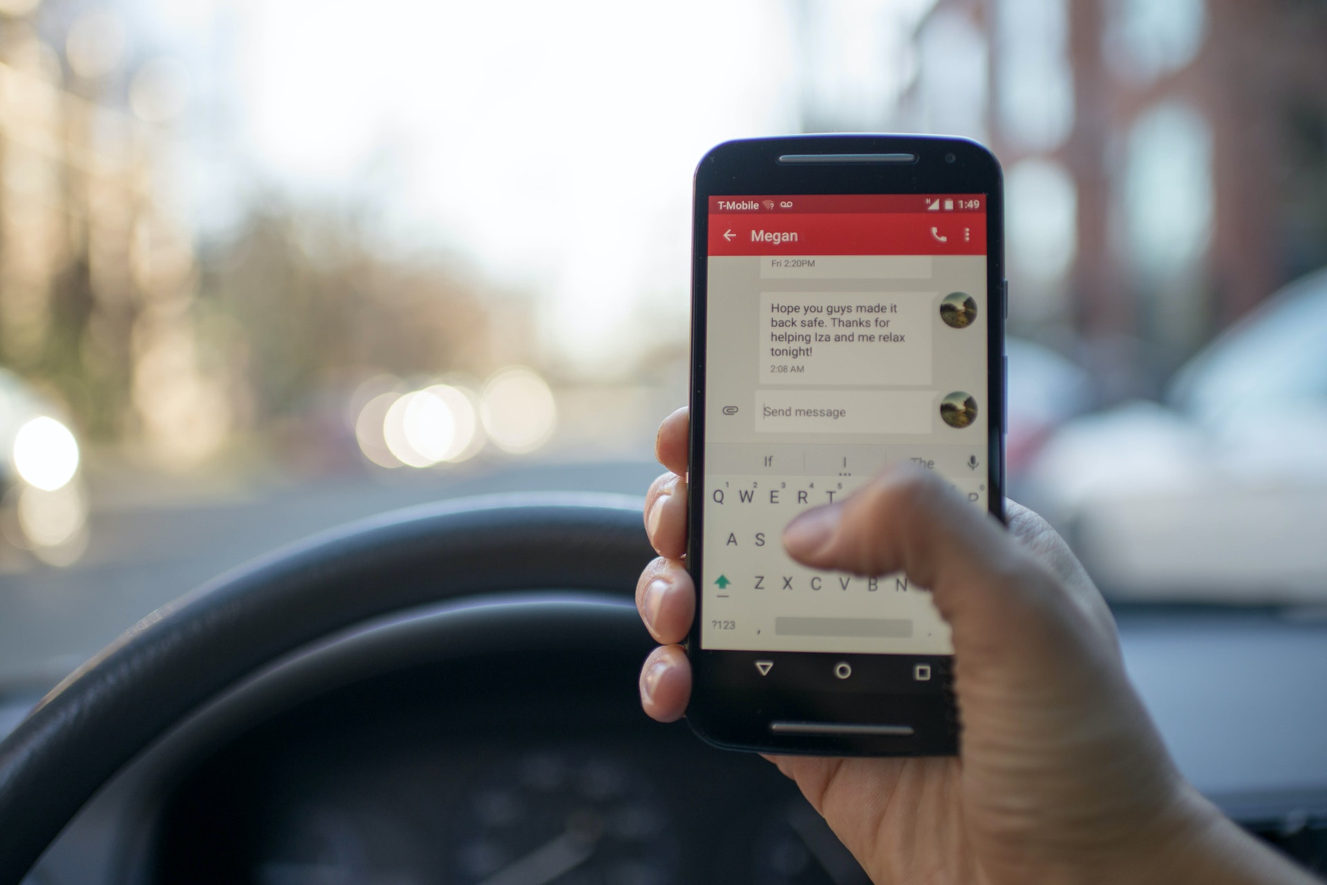 Imagem de uma mão segurando um celular próximo ao volante de um carro. Imagem ilustrativa texto microfranquia home office.