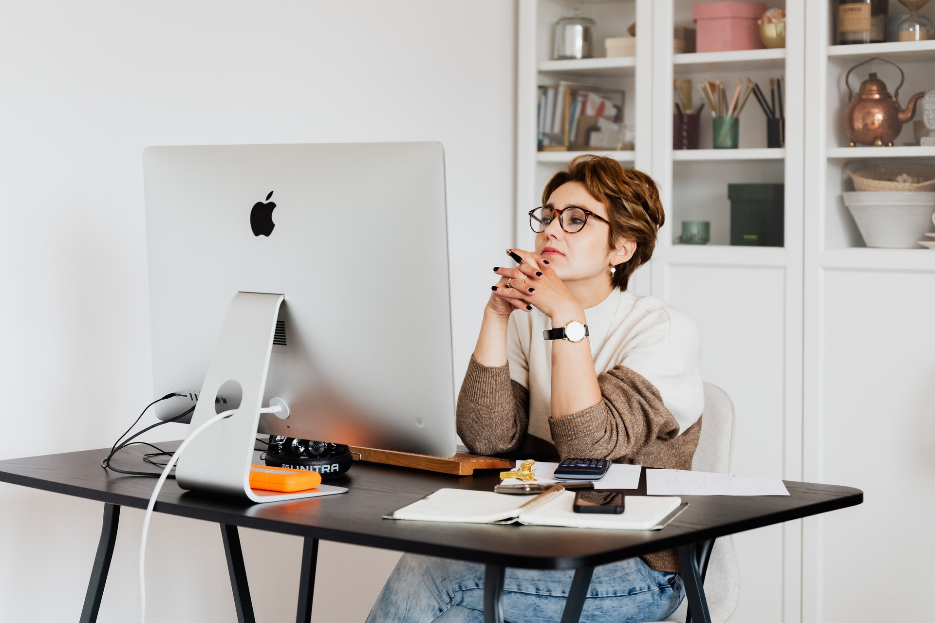 Imagem de uma empresária sentada em frente a um computador na sala de casa. Imagem ilustrativa texto vantagens de se tornar um franqueado.
