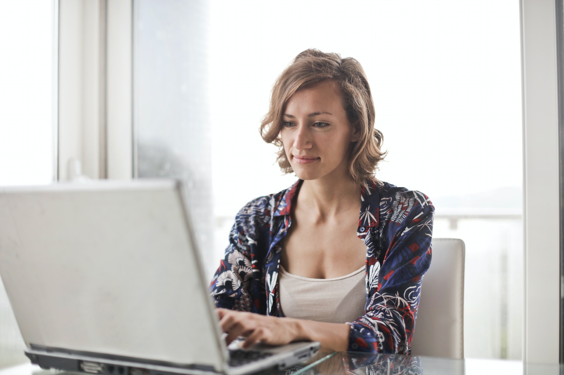 Mulher sentada em frente a um computador. Imagem ilustrativa do texto como ter independência financeira com franquia.