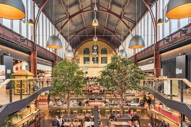 imagem de shopping com árvores dentro e pessoas sentadas em mesa ilustração para empreender do zero em 2022