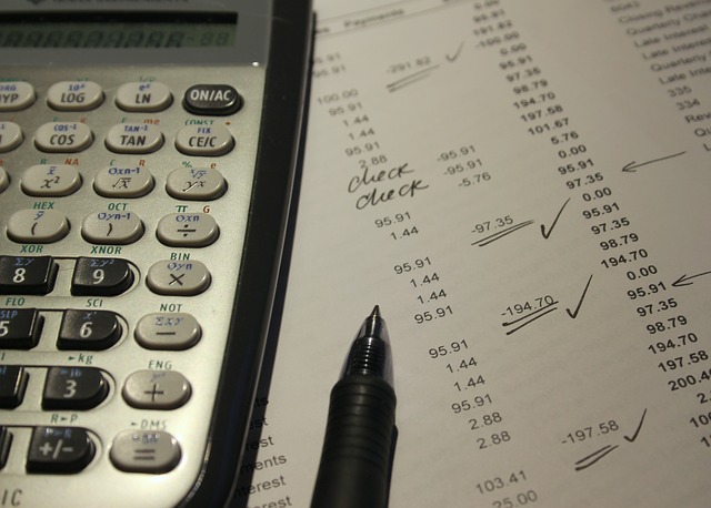 Papel com contas e caneta em cima ao lado de calculadora. Ilustração do texto sobre franquia da dinheiro.