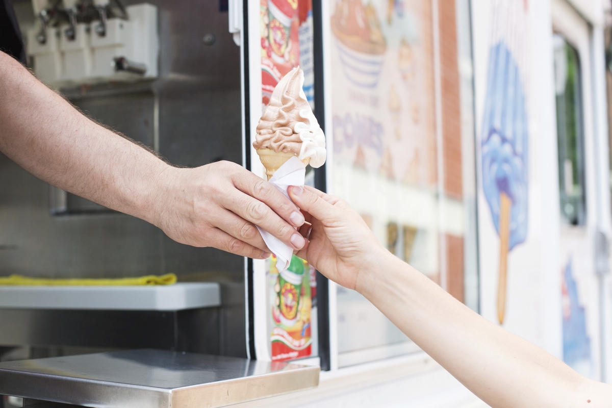 Pessoa comprando casquinha de sorvete em food truck. Ilustração do texto sobre franquia de container.