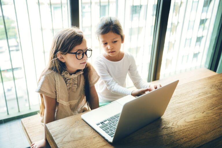 Duas meninas usando computador. Ilustração do texto sobre franquia de cursos para crianças.