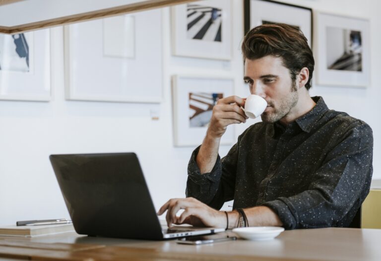 Homem em frente a computador tomando café. Ilustração do texto sobre ideias de empreendimentos.