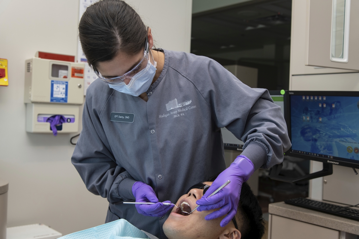Dentista atendendo jovem paciente.