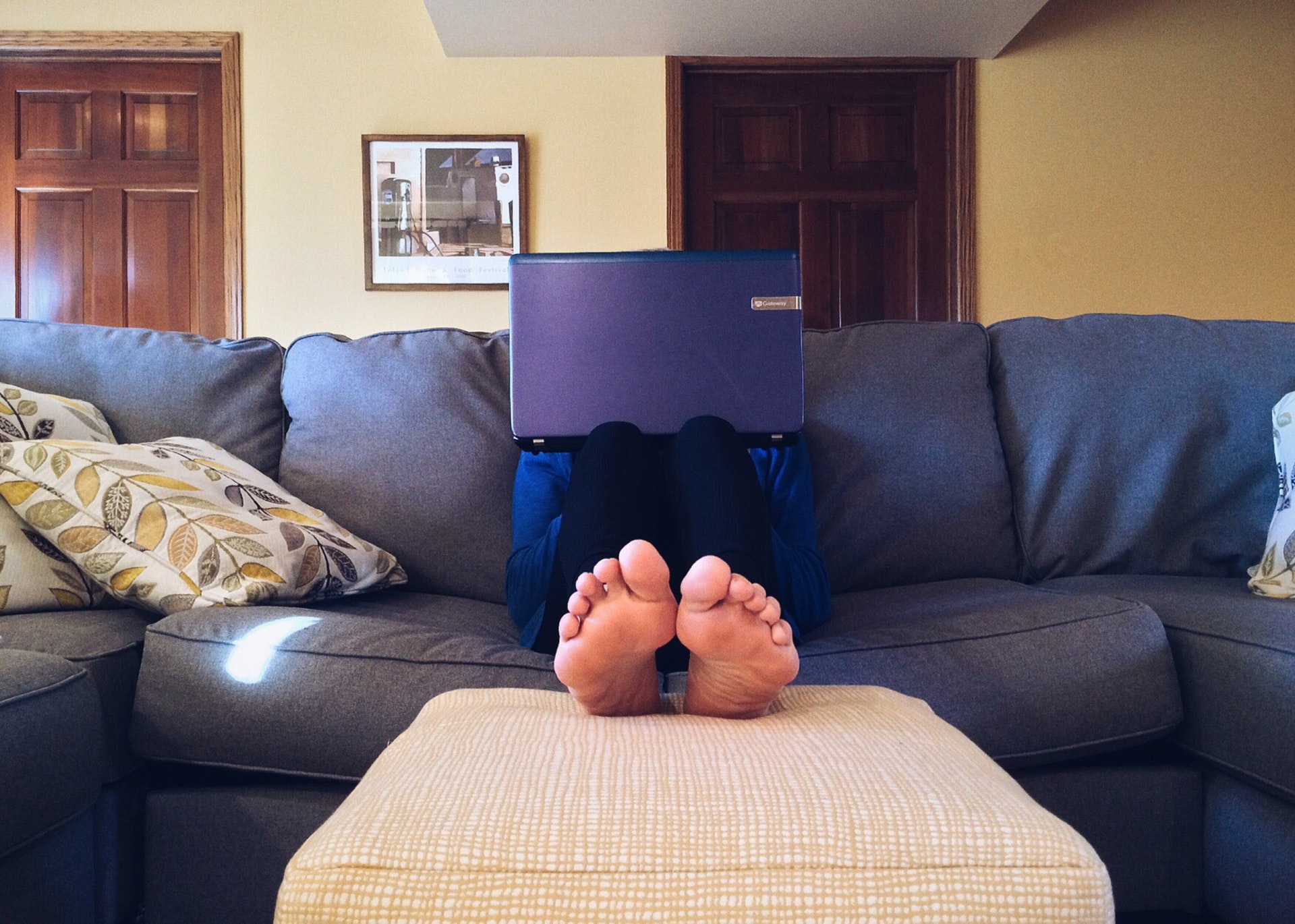 Pessoa sentada em um sofá com um computador no colo. Imagem ilustrativa do texto pequenos negócios rentáveis.